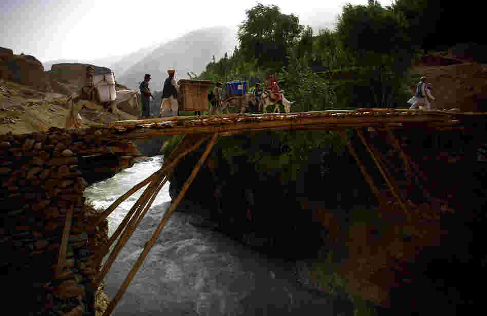 Donkeys, their handlers and the Afghan National Police escort a load of voting materials over a handmade bridge en route to the village of Quali Kuana.