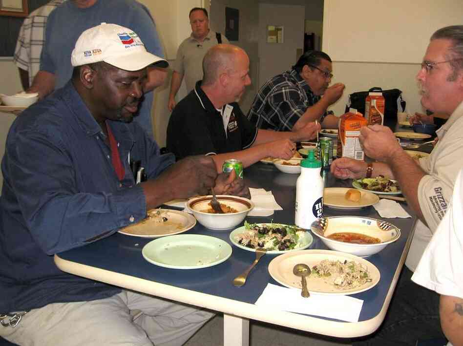 Reggie Russell (left foreground) eats a meal carefully prepared in Hammack's kitchen at the Bay Area Rescue Mission in Richmond, Calif.