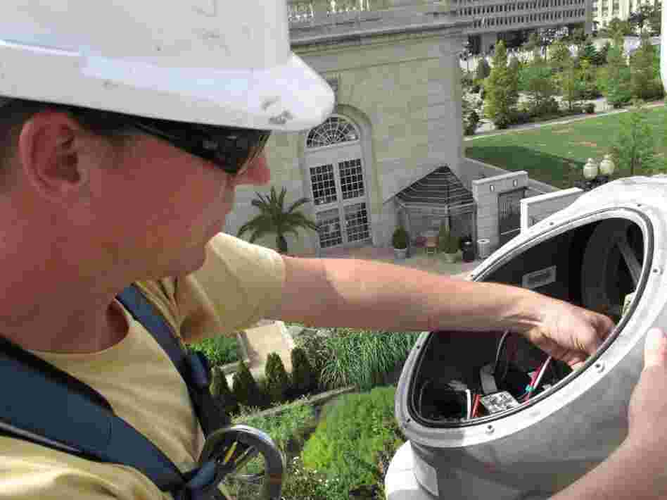 A Southwest Windpower field engineer works on the Skystream wind turbine at the U.S. Botanic Garden. Credit: Franklyn Cater/NPR