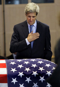 Sen. John Kerry, D-Mass., pays his respects at Kennedy's flag-draped casket inside the JFK Library in Boston Friday.