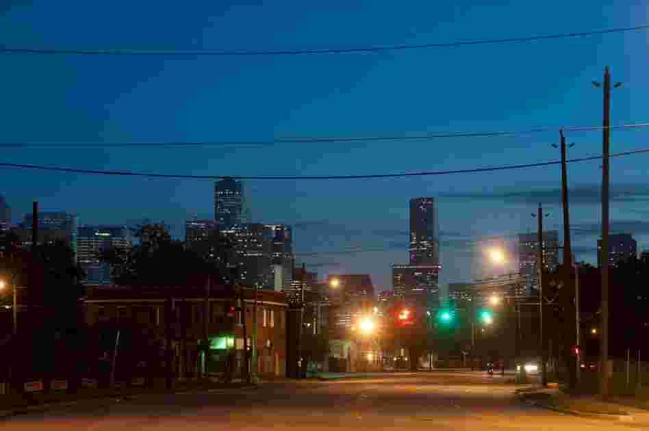 The contrast between downtown Houston and the Third Ward can be seen from a deserted street at night.