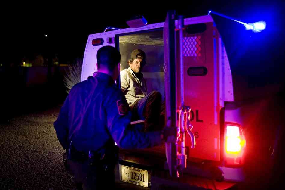 A man is detained by the Border Patrol after being spotted by a citizen and reported to officials near Green Valley, Ariz., on Aug. 9.