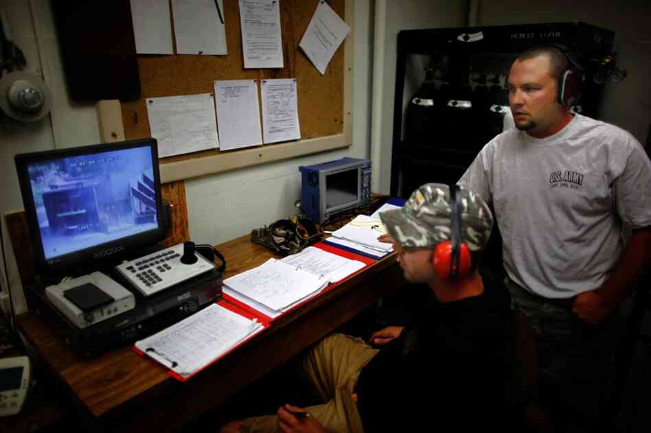 Inside a bunker, explosives experts watch a live explosion on closed-circuit television.