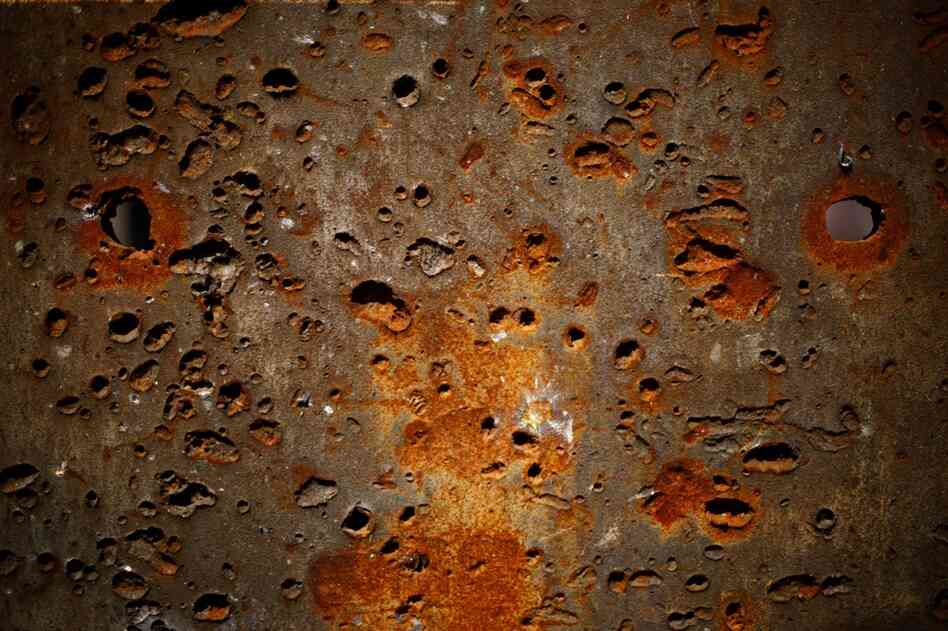 Holes in an Aberdeen blast wall appear like eyes overlooking the site.
