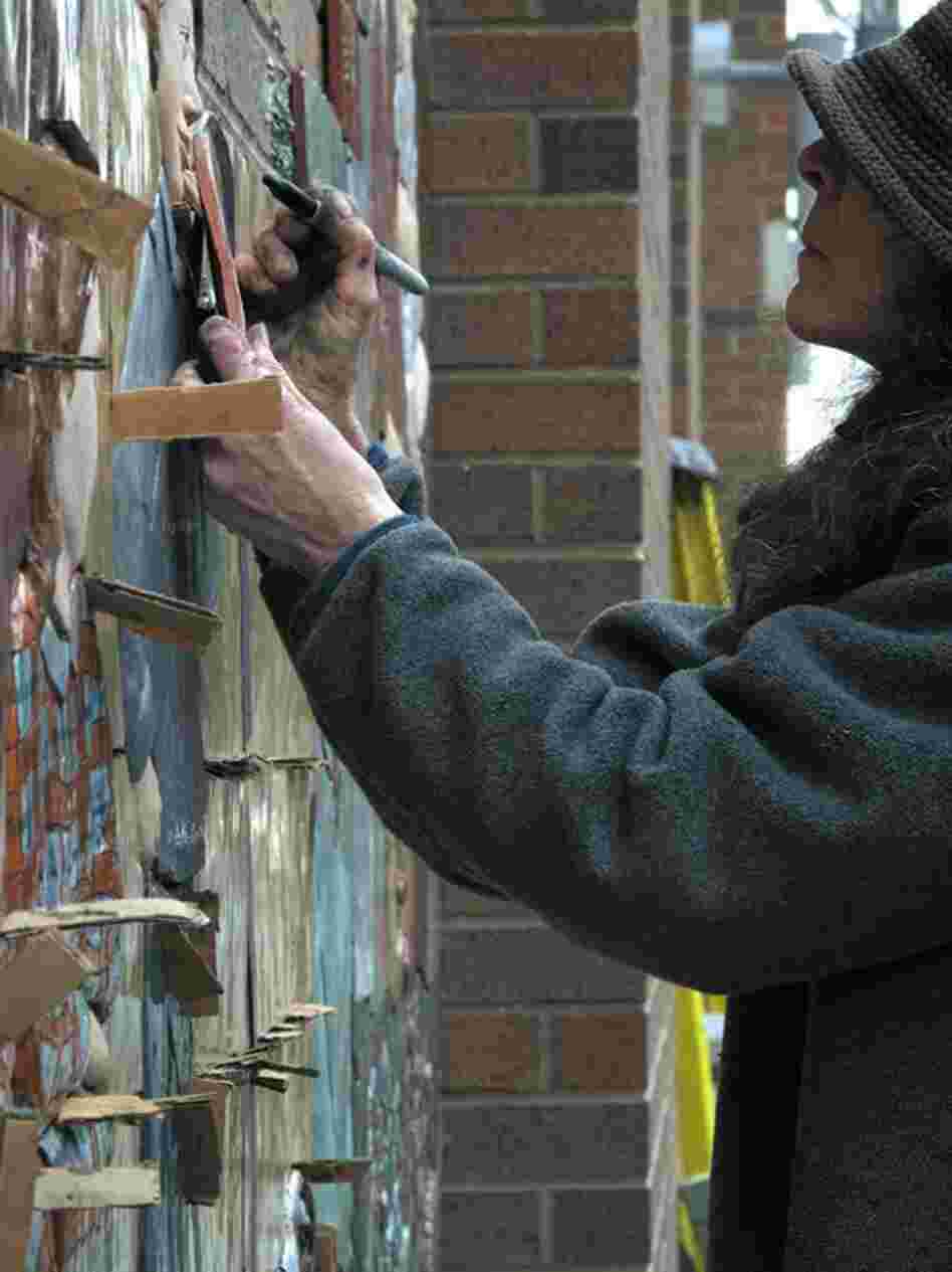 Judith marks each of the spacer tiles that will be placed around the central elements of the mural.