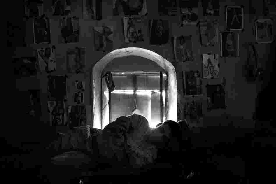 After sleeping on the ground for weeks, the men say that their newly acquired cots feel luxurious. Lance Cpl. Sergio Navarette sleeps against a mud wall decorated with magazine "art."