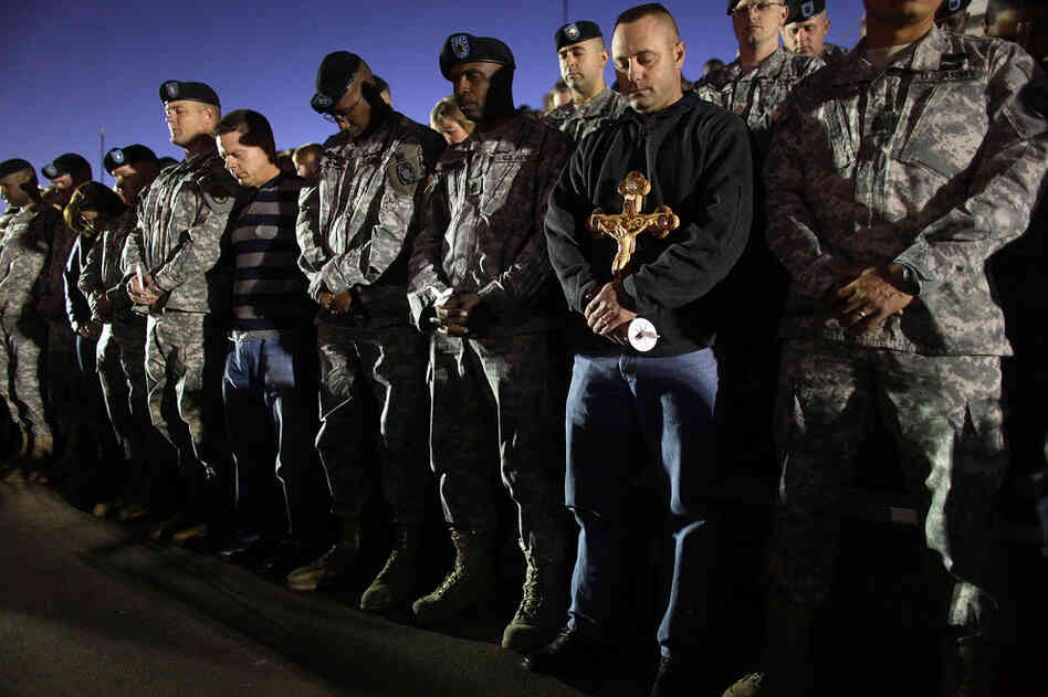 Soldiers bow their heads in prayer during a vigil at Fort Hood on Friday. 