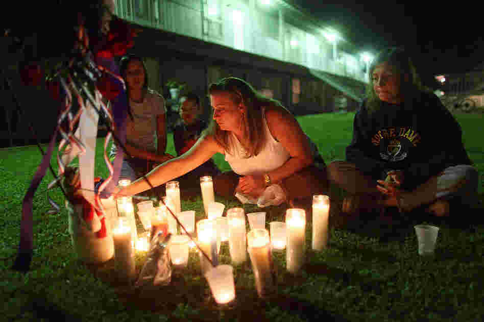 Kolleen Alldridge (from left), Gavyn Alldridge, Kim Rosenthal and Alice Thompson light candles Saturday at a small memorial in the courtyard of the apartment complex where Maj. Nidal Malik Hasan lived prior to the Fort Hood shooting. 