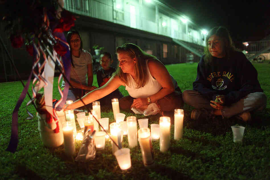Kolleen Alldridge (from left), Gavyn Alldridge, Kim Rosenthal and Alice Thompson light candles Saturday at a small memorial in the courtyard of the apartment complex where Maj. Nidal Malik Hasan lived prior to the Fort Hood shooting. 