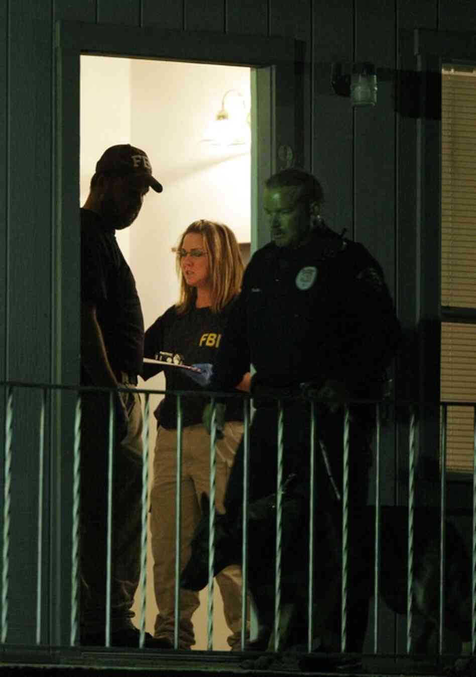 Federal agents search Hasan's apartment in Killeen early Friday. Hasan, an Army psychiatrist, was unconscious and on a ventilator Friday, contrary to early reports that he had been killed. 