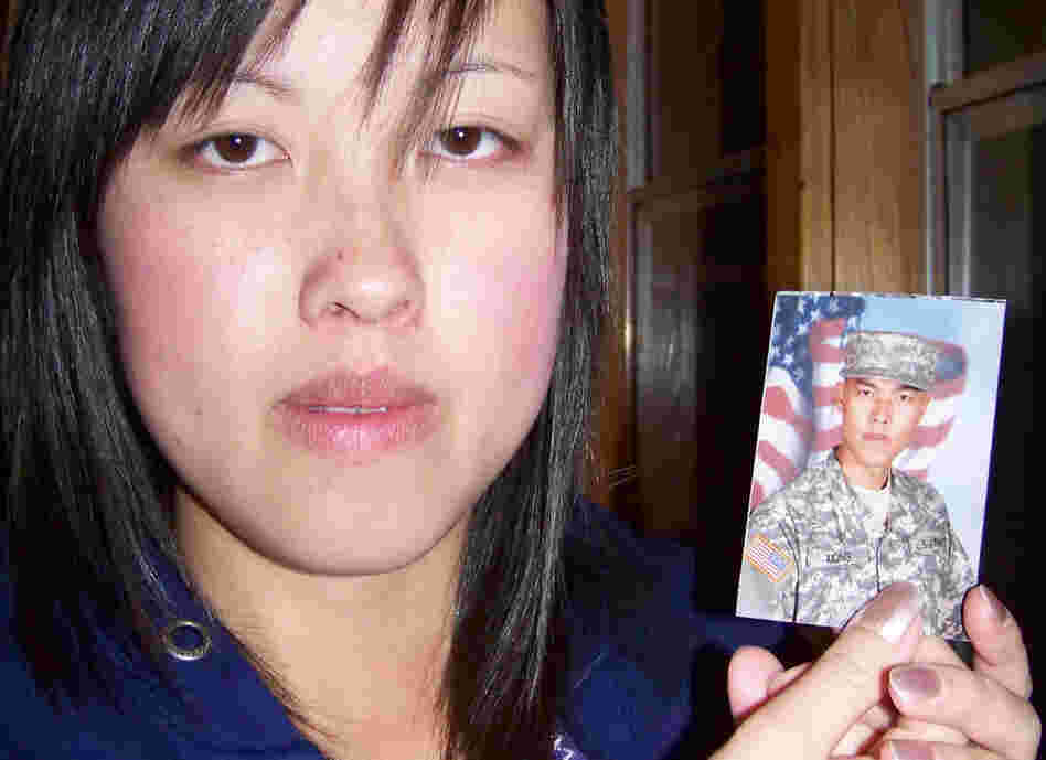 Kham XiongMee Xiong of St. Paul, Minn., holds a photo of her older brother, Kham Xiong, 23. Originally from Laos, Kham came to the U.S. as a toddler. He leaves behind a wife and three children. 