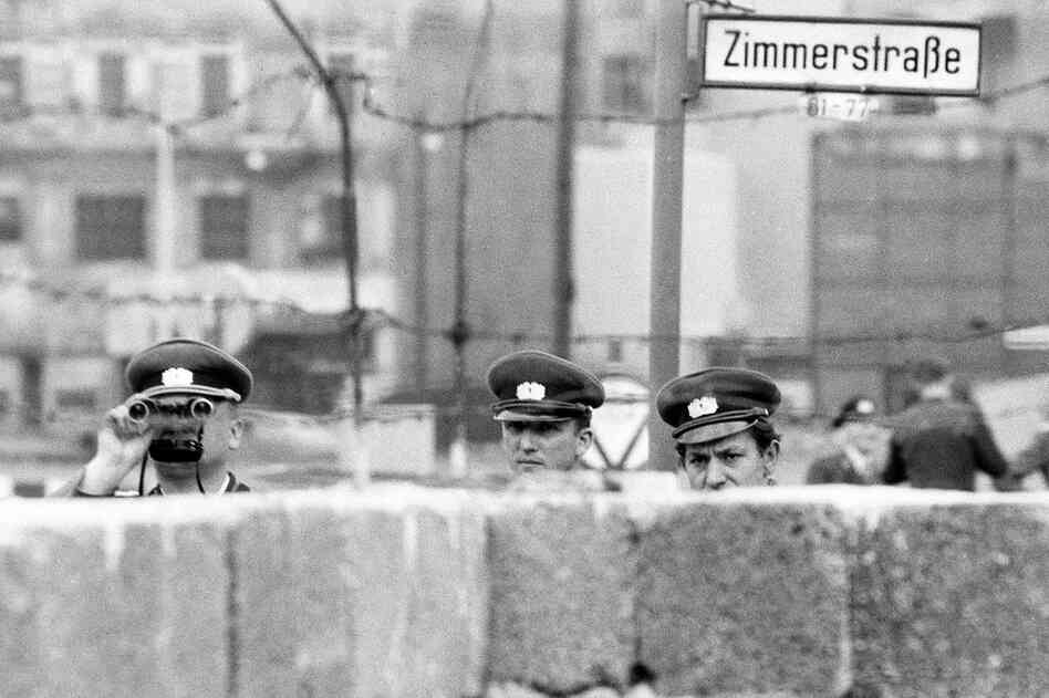 East German policemen peer into West Berlin over a temporary portion of the Berlin Wall. East Berliners were closely monitored by the notorious Stasi, the Ministry for State Security. 