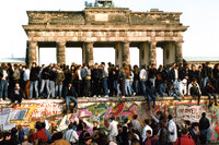 People walk freely atop the Berlin Wall in front of the Brandenburg Gate on Nov. 10, 1989, one day after the border between East and West Berlin was opened.