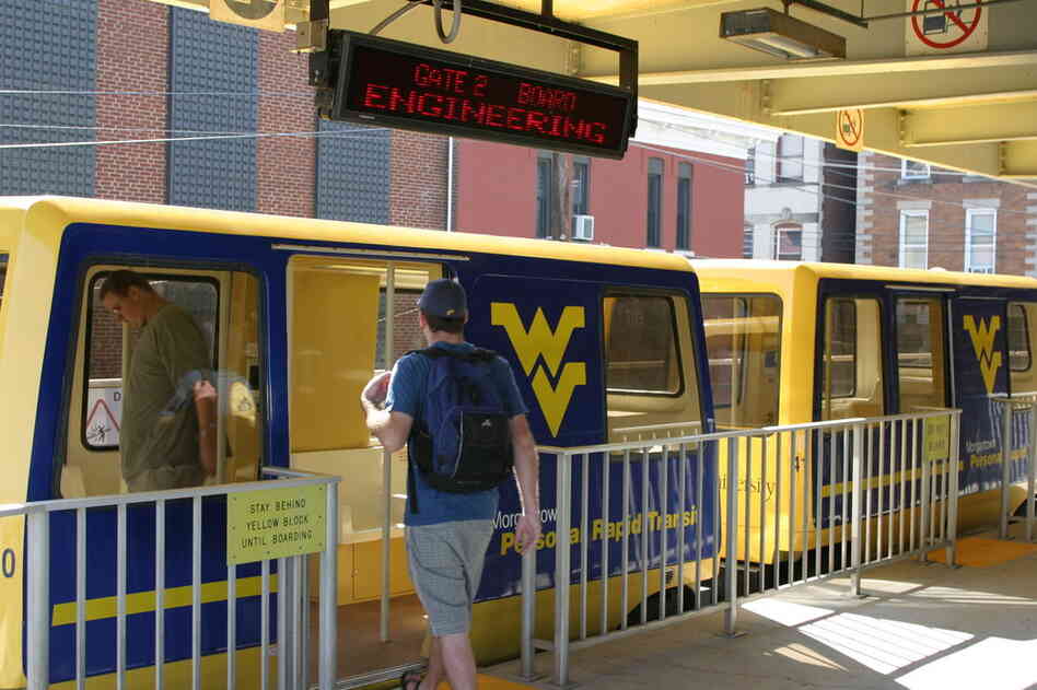 A student boards the West Virginia University pod car at one of the five platforms along the route. The system was constructed in 1975 and can transport about 4,000 people an hour. 