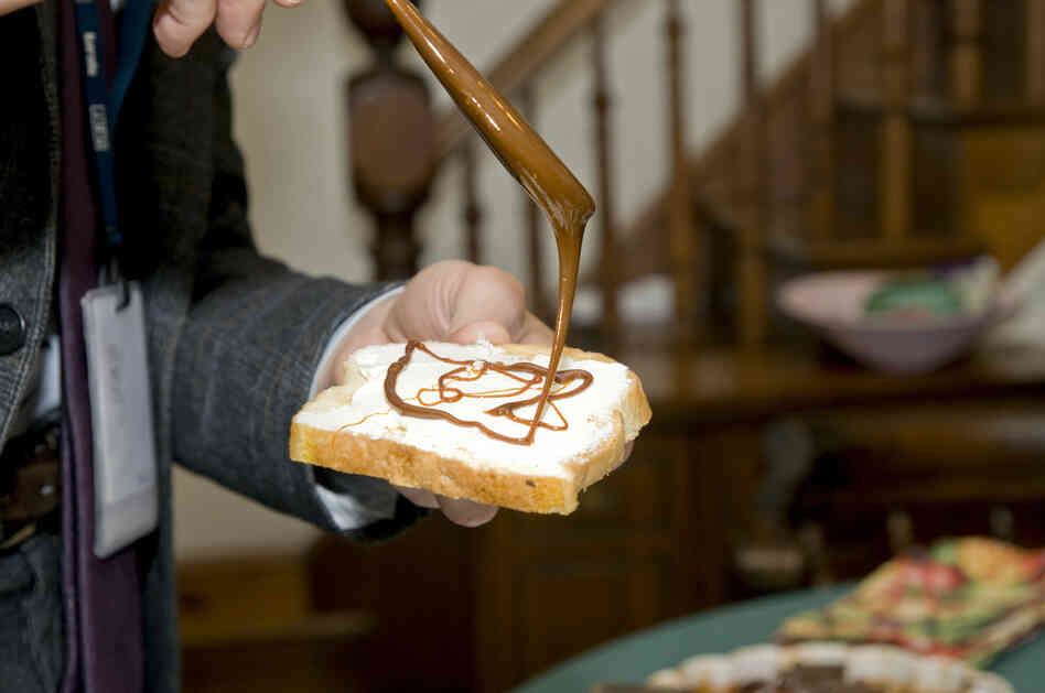 Weekend All Things Considered host Guy Raz drizzles Marmite on a piece of buttered white toast.