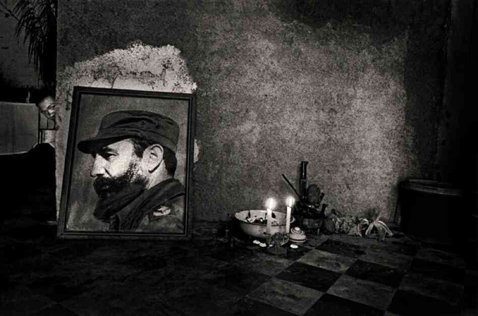 A man peers around the corner at a Santeria altar, Havana, 1995.