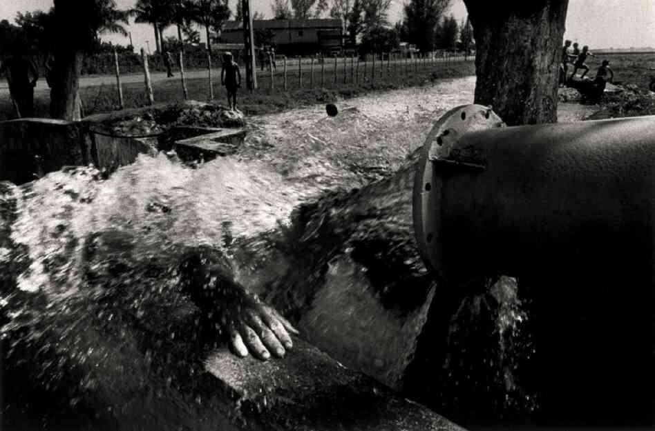 A man showers on a hot summer day, near Giron, 1996.