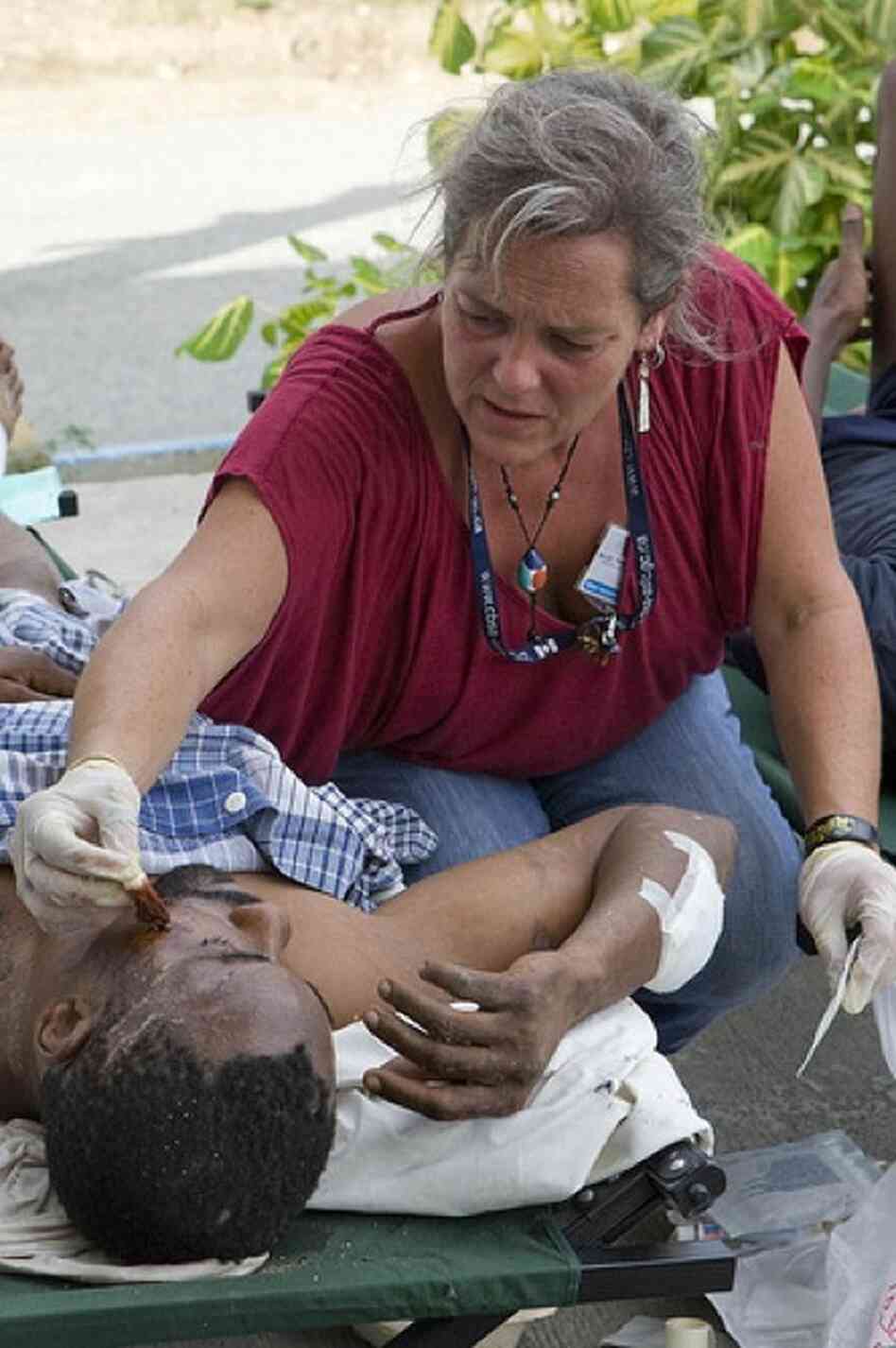 A staff member from the U.N. Stabilization Mission in Haiti, or MINUSTAH, treats an injured man. 