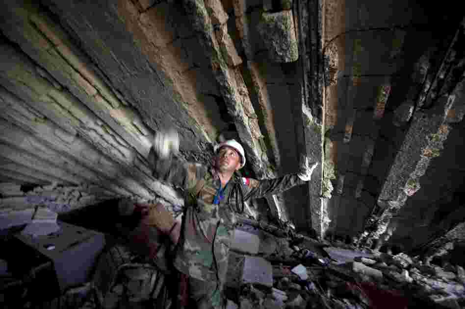A U.N. peacekeeper from Chile works in the rubble of the Montana Hotel. 
