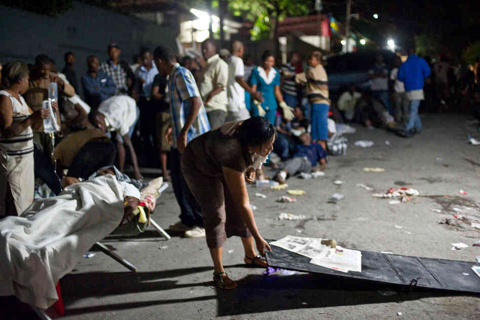 A woman prepares a bed in the street Tuesday night after the quake. 