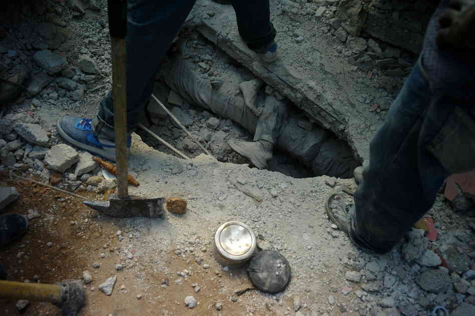 Workers dig for bodies in a fight against time. 
