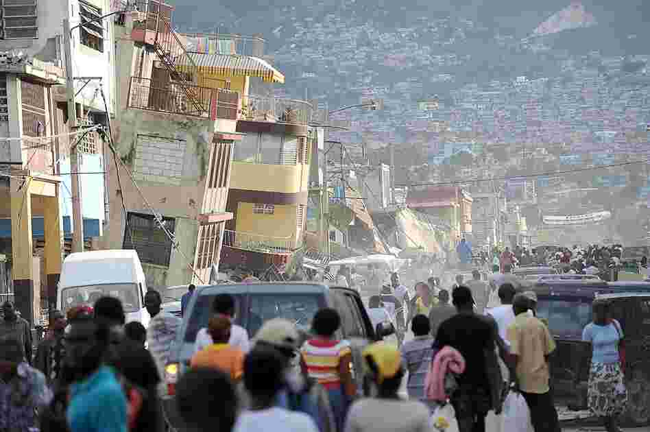 Haitians walk though streets filled with rubble and bodies. 