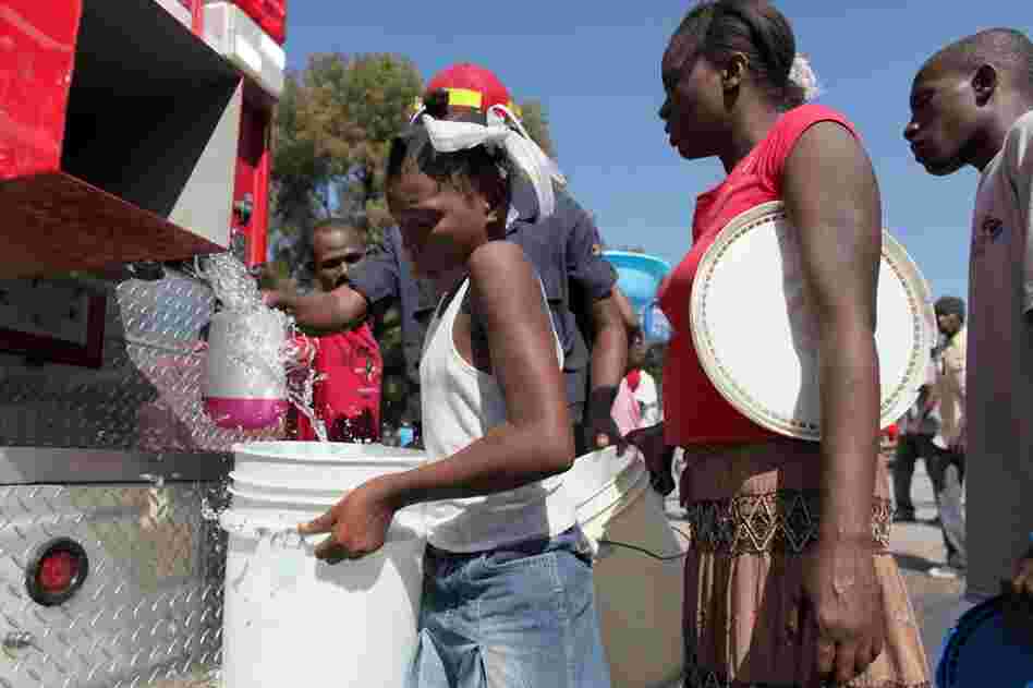 People line up to receive water, an in-demand commodity, from a firetruck in Port-au-Prince.  