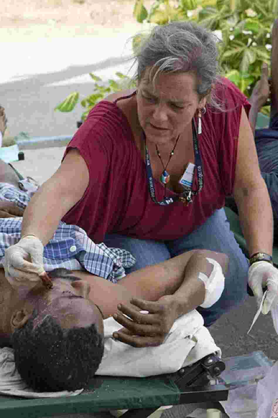 A staff member from the U.N. Stabilization Mission in Haiti, or MINUSTAH, treats an injured man. 
