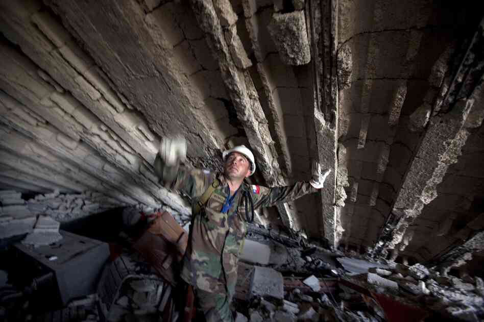 A U.N. peacekeeper from Chile works in the rubble of the Montana Hotel. 