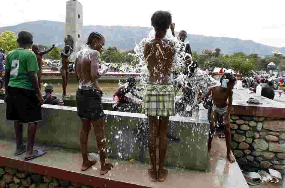 Earthquake survivors use water from a fountain to bathe in the central public garden of Port-au-Prince. 
