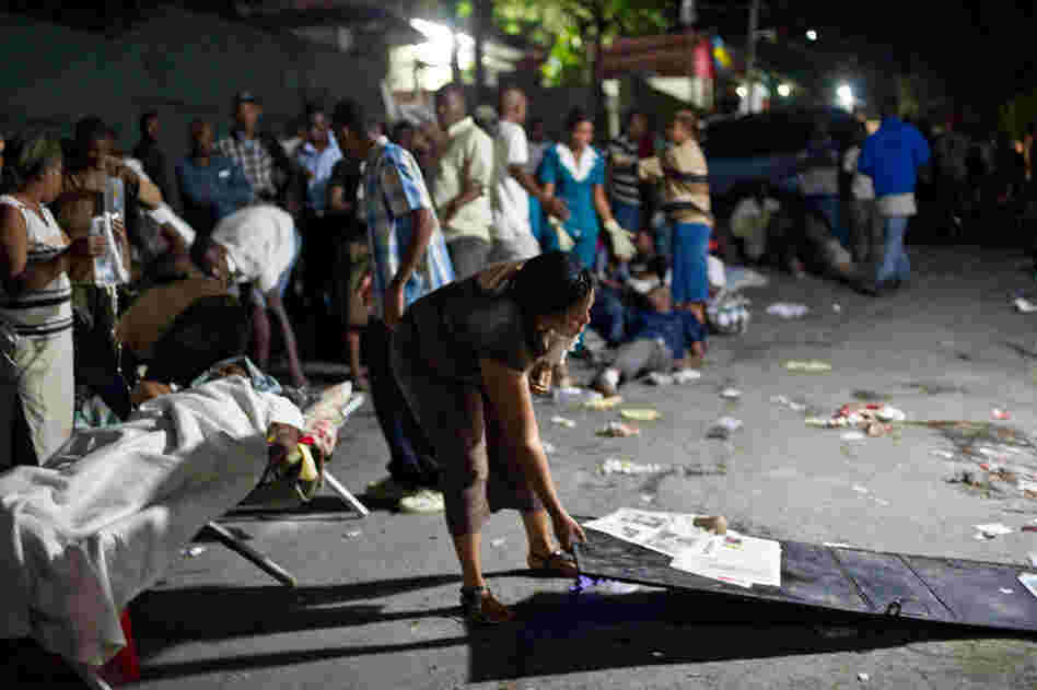 A woman prepares a bed in the street Tuesday night after the quake. 