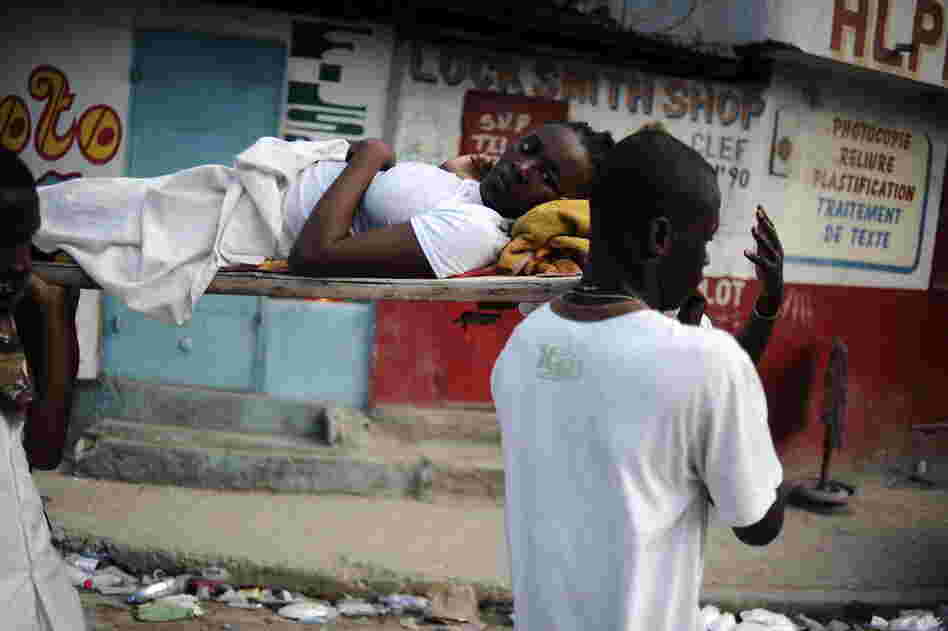 Rescuers carry an injured girl down the street after digging her out of the rubble Thursday. 