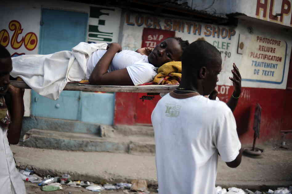 Rescuers carry an injured girl down the street after digging her out of the rubble Thursday. 