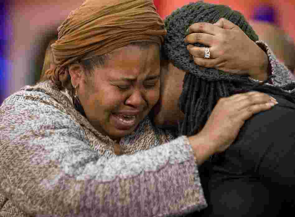 Members of Canada's Haitian community comfort each other at the Haitian-Canadian Community Center in Montreal. 