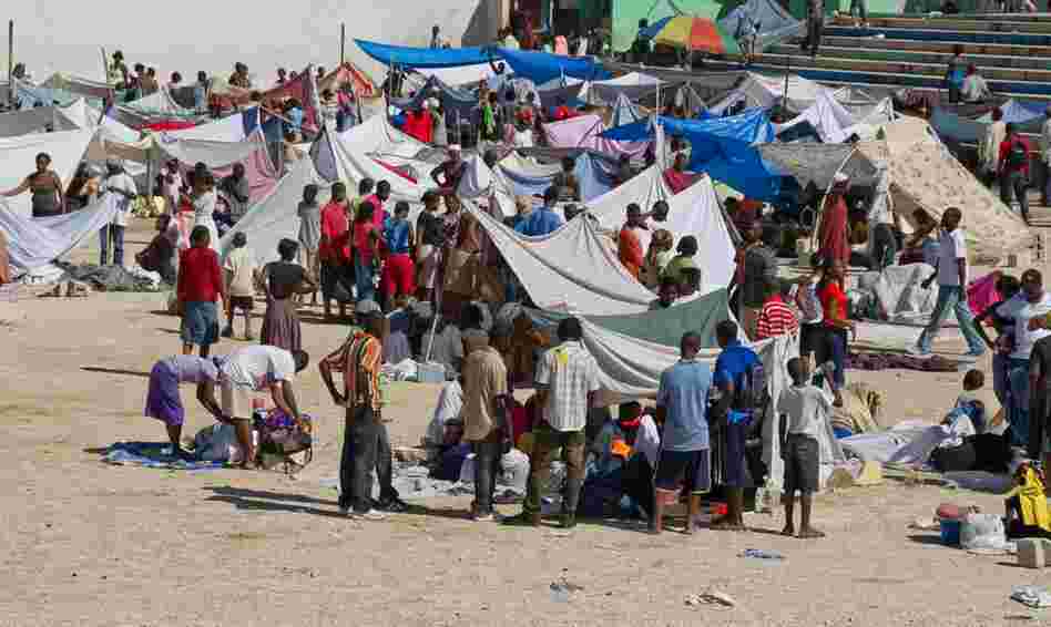 Displaced people create makeshift shelters out of tarps and sheets. 