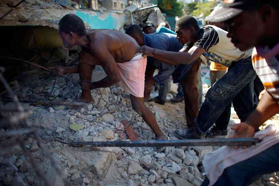 Haitian men dig for a relative in a collapsed house outside of the capital.
