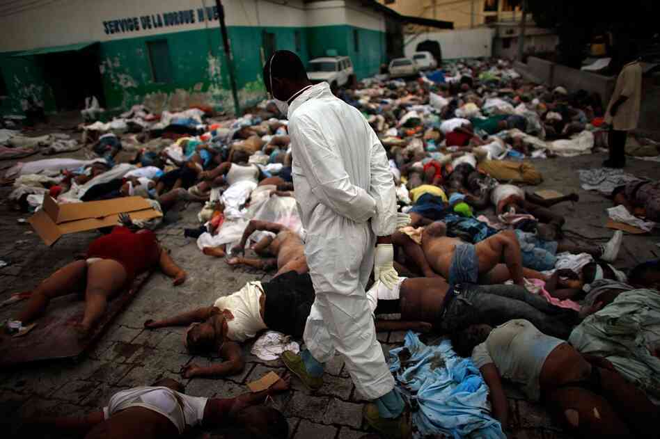Workers are trying to deal with the thousands of bodies piling up at the central morgue at the National Hospital in Port-au-Prince.