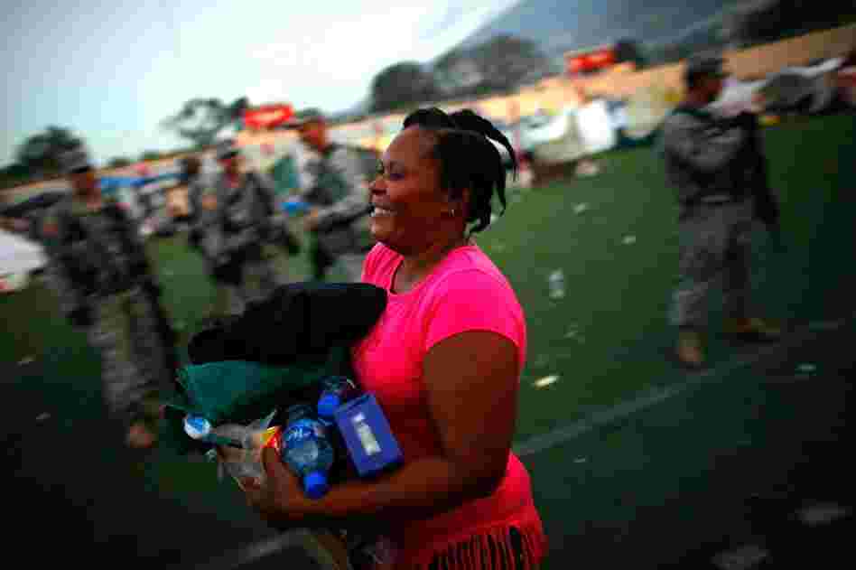 A Haitian woman receives her first ration of foreign aid in a soccer stadium in Port-au-Prince on Saturday.