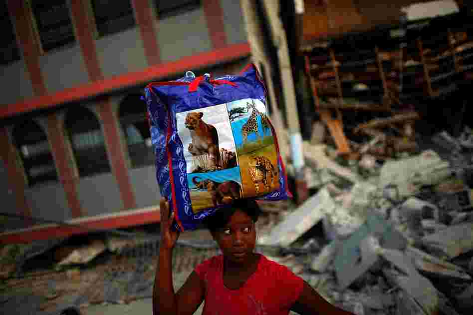 Across Port-au-Prince Haitians are scrambling to salvage what they can. A woman carries a bag of clothing recovered from her apartment.