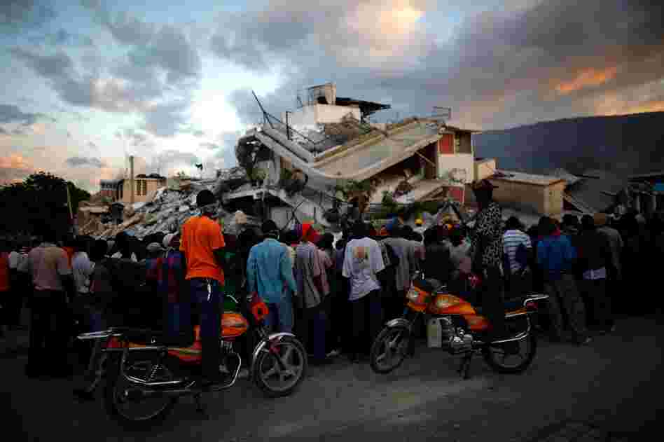 Haitians watch the L.A. rescue team's efforts at a collapsed building. Officials estimate at least 50,000 people were killed by the quake.