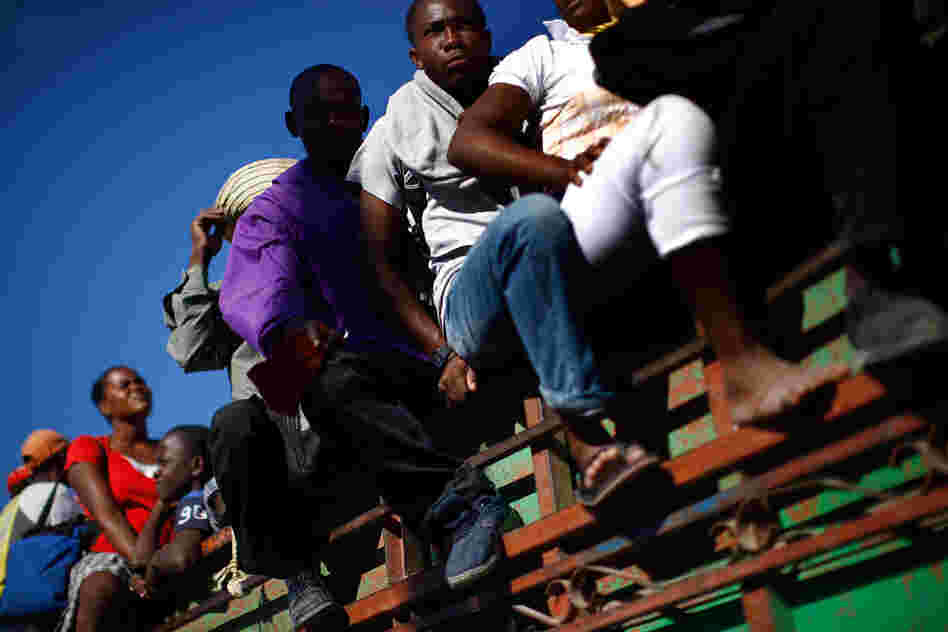 Haitians leave Port-au-Prince on a flatbed truck. Other towns in Haiti were also hit hard, but not much aid has made it beyond the devastated capital.