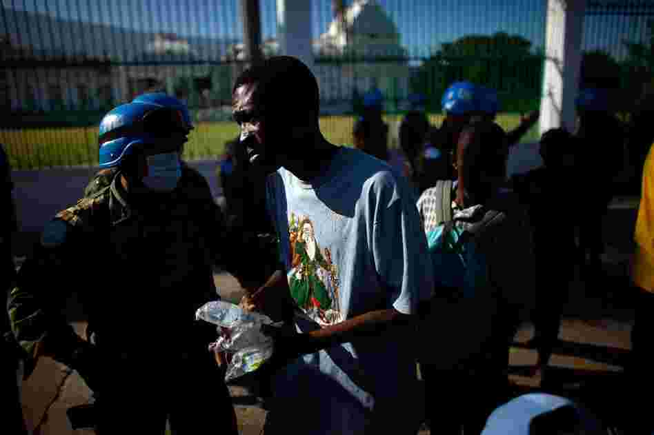 United Nations soldiers hand out water in front of the National Palace on Sunday.