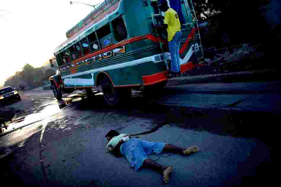 A body, with tied limbs and apparent gunshot wounds to the head, lies in the street Monday.