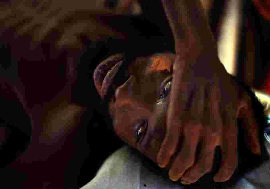 Robenson Bernard cries at a hospital in downtown Port-au-Prince on Monday. Bedridden since November, none of the family members who used to take care of him have come since the quake.