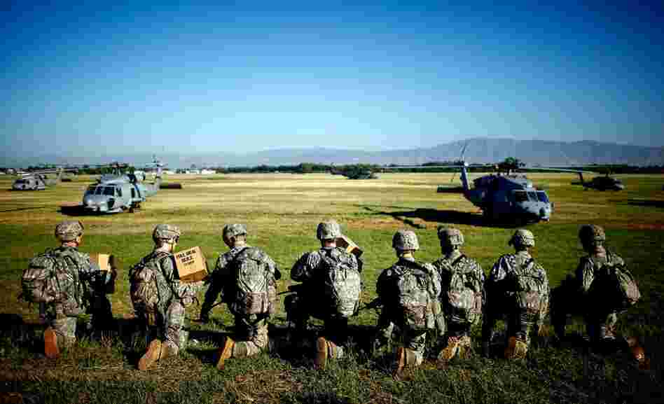 Soldiers with the U.S. Army's 82nd Airborne Division prepare to board helicopters to create operating bases across Port-au-Prince on Monday.