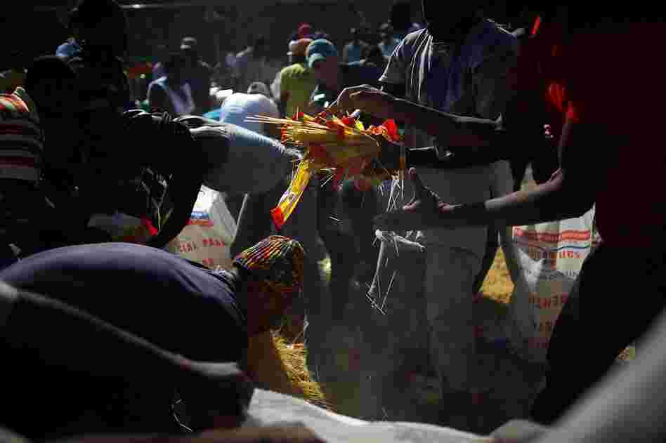 People scramble to pick up spilled spaghetti at the burning restaurant. With food supplies already low, the fire is yet another blow to a desperate capital.