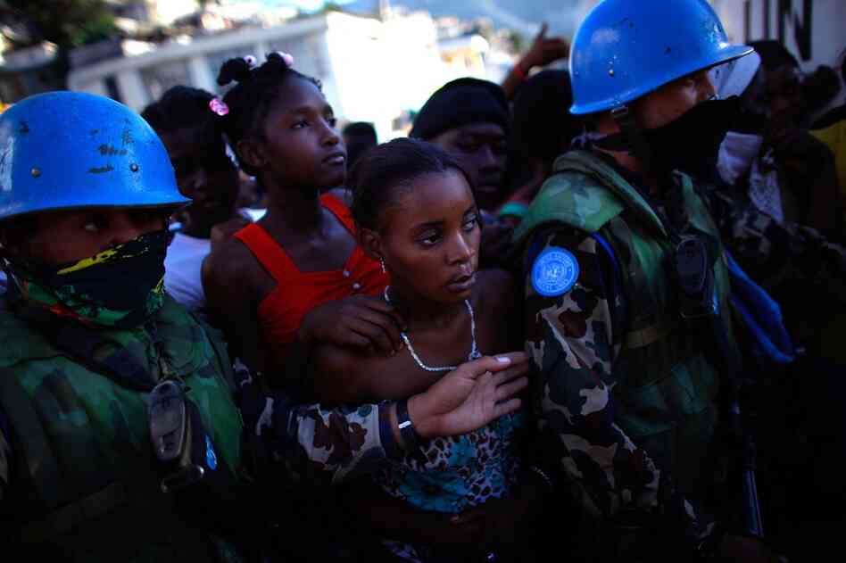 Women stand in line for food rations being handed out by the United Nations Friday in Port-au-Prince.