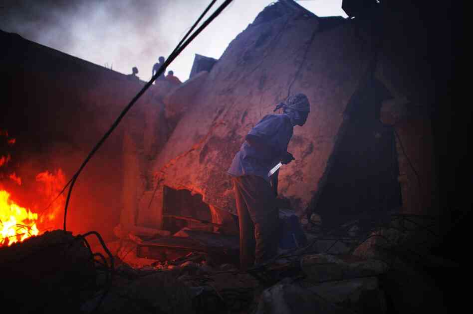 A man grips a knife as he looks for other looters to come out of a shop near downtown Port-au-Prince on Sunday.