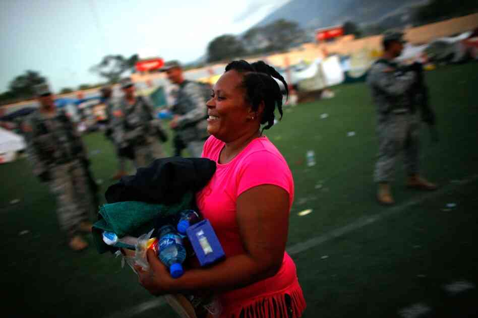 A Haitian woman receives her first ration of foreign aid in a soccer stadium in Port-au-Prince on Saturday.