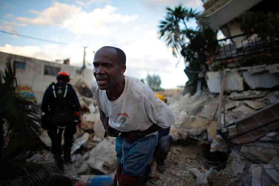 The search for people in the rubble continues. A Haitian rescue worker helps the L.A. County Search and Rescue team in in downtown Port-au-Prince.